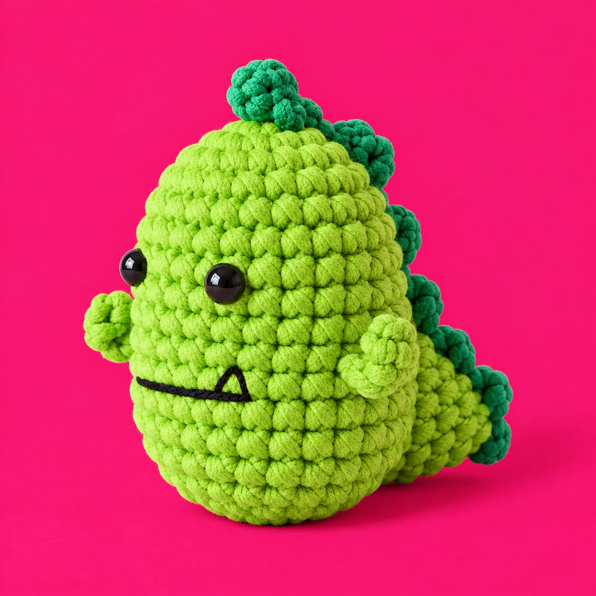 Fred — Dinosaure au crochet de trois quarts, avec sa crête et sa queue vert foncé.