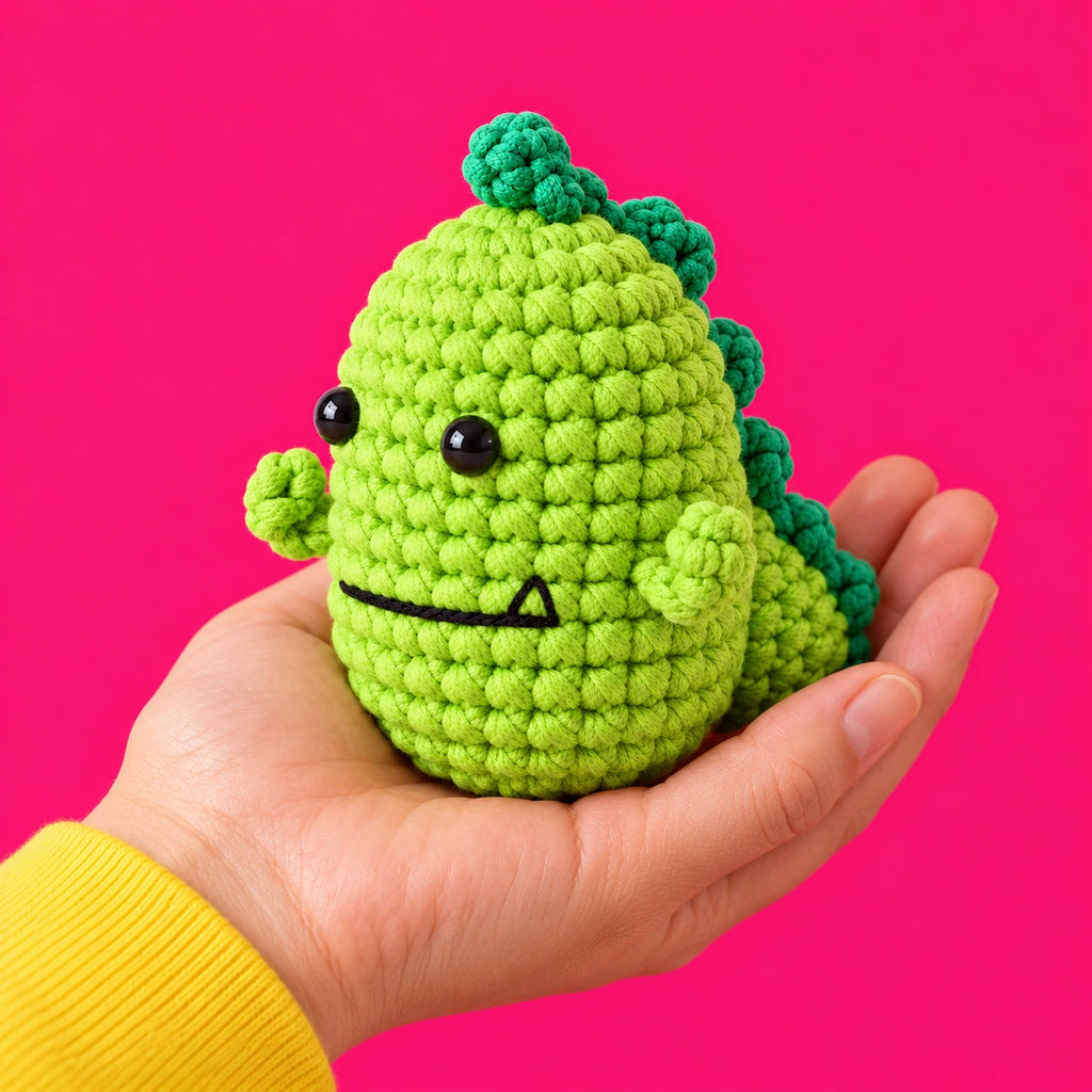 Fred — Dinosaure au crochet présenté dans une main.