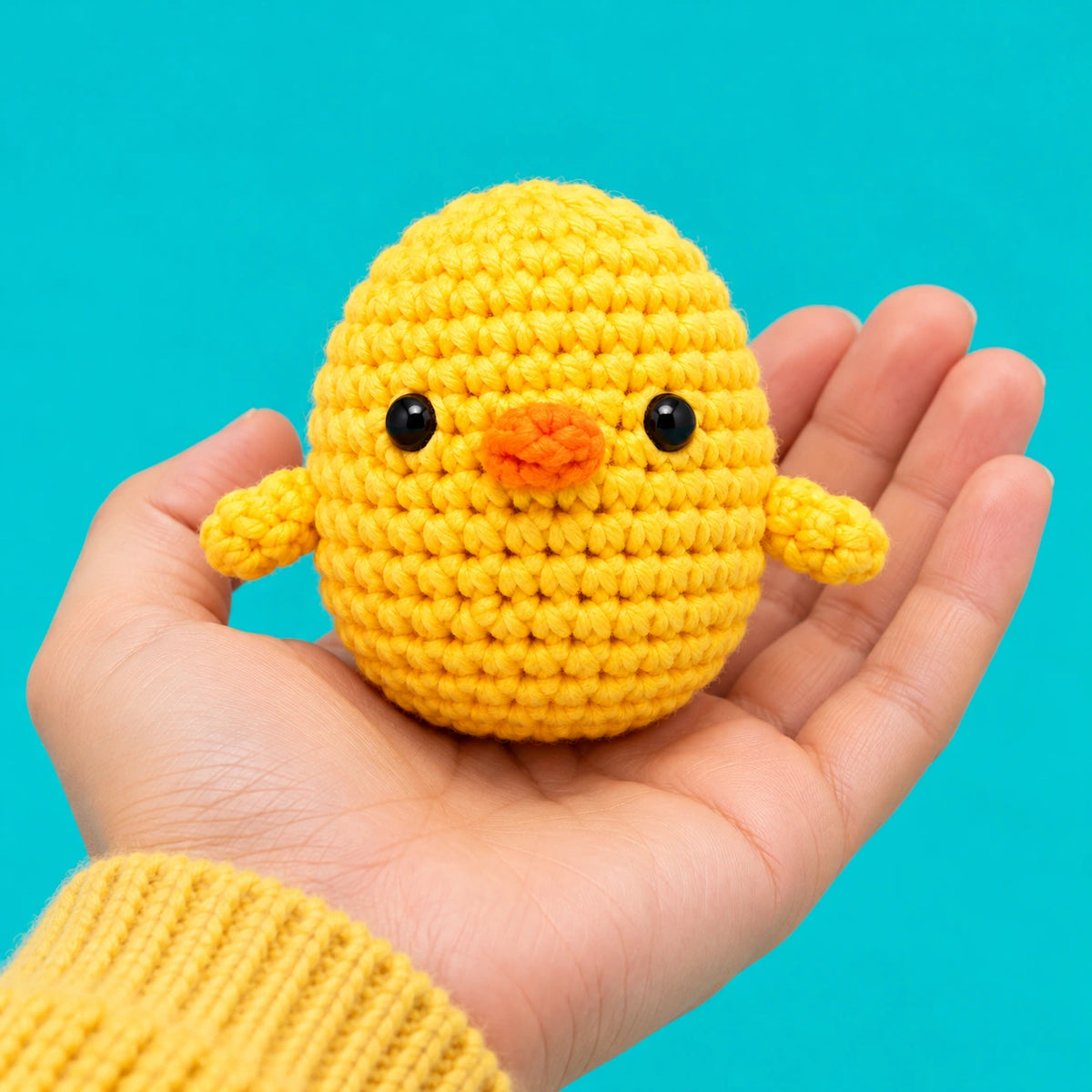 Nino — Le poussin jaune au crochet — présentation en main.